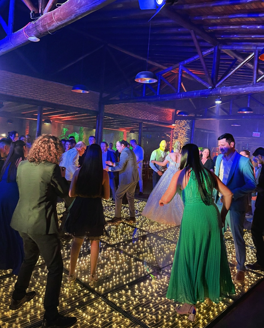 Casal e convidados dançando na pista iluminada em casamento
